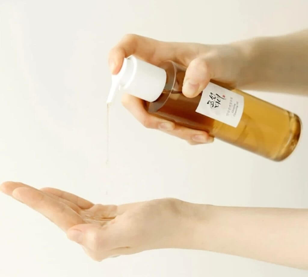 Person dispensing Beauty of Joseon Ginseng Cleansing Oil into hand for a skincare routine.