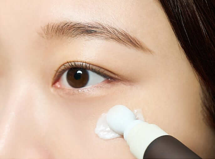 Close-up of a person applying Skin1004 Madagascar Eye Cream under the eye, enhancing skin elasticity and reducing fine lines.