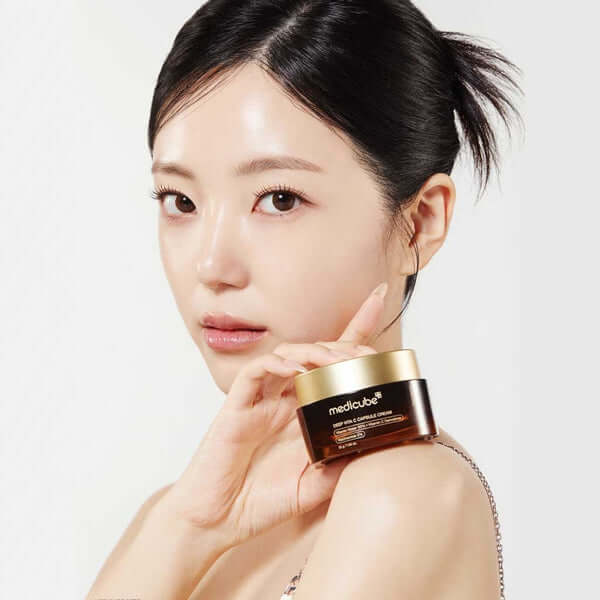 Medicube Deep Vita C Capsule Cream displayed by a model, promoting brightening and skin elasticity enhancement.