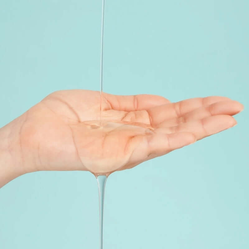 Numbuzin No.1 Pantothenic B5 Active Soothing Serum being poured onto a hand against a teal background.
