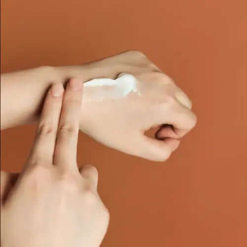 Applying SKIN1004 Madagascar Centella Probio-Cica Enrich Cream on a hand, showcasing its rich, creamy texture.