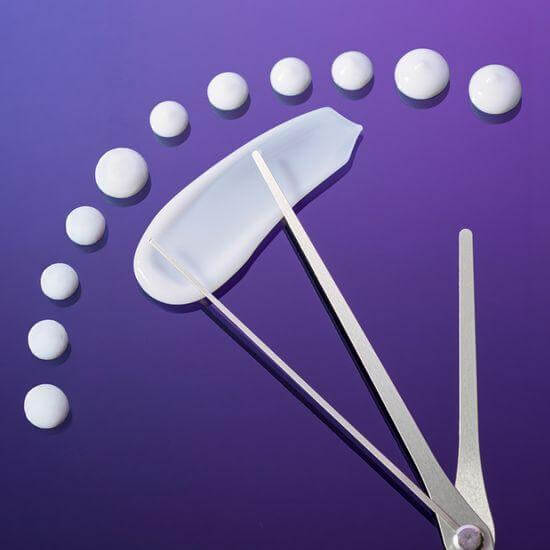 Display of skincare textures showcasing product viscosity on a purple background with precision tools.