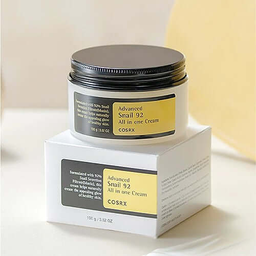 COSRX Advanced Snail 92 All In One Cream jar on a box, promoting hydration and skin repair for all skin types.