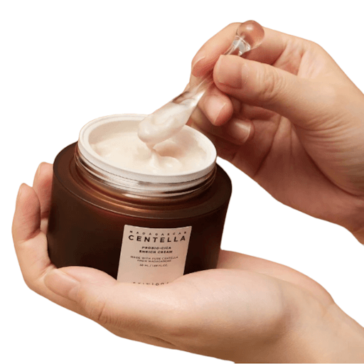 SKIN1004 Madagascar Centella Probio-Cica Enrich Cream being applied from a jar, showcasing its rich, buttery texture.