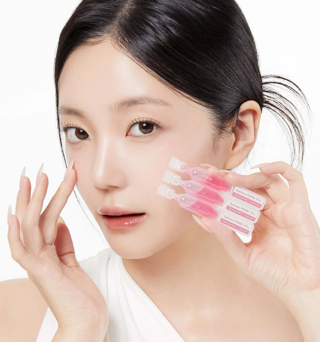Model showcasing Medicube PDRN Pink One Day Serum vials for skin radiance and elasticity.